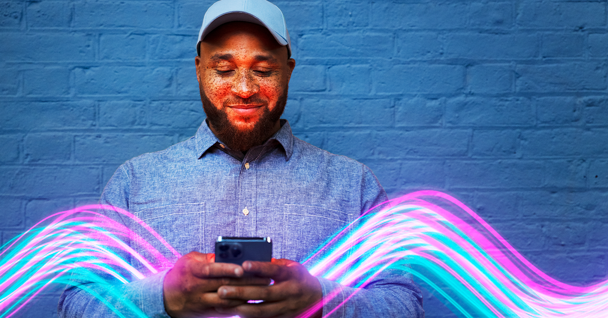 a man in a white hat and purple shirt holding a phone