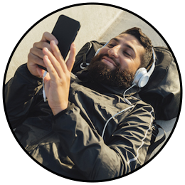 a person lying down with headphones on and holding a phone