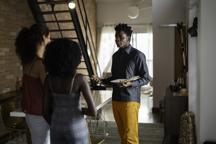 Man giving two prospective renters a tour of an apartment unit