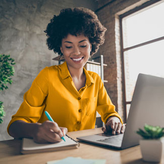 a person smiling while using a laptop