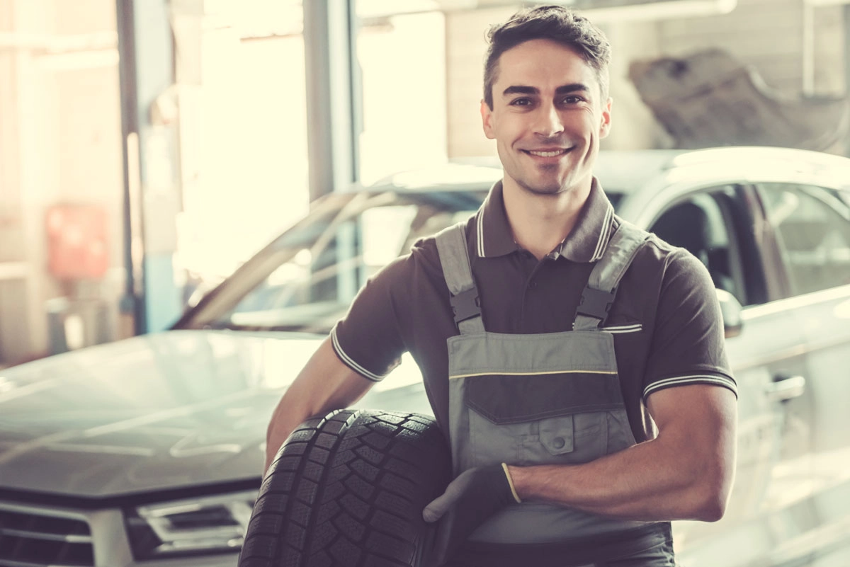 Man holding tire a person with the arms crossed
