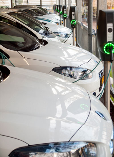 row of electric vehicles at a charging station