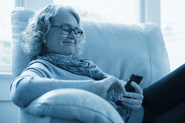 Woman relaxing on a chair and looking at her phone screen