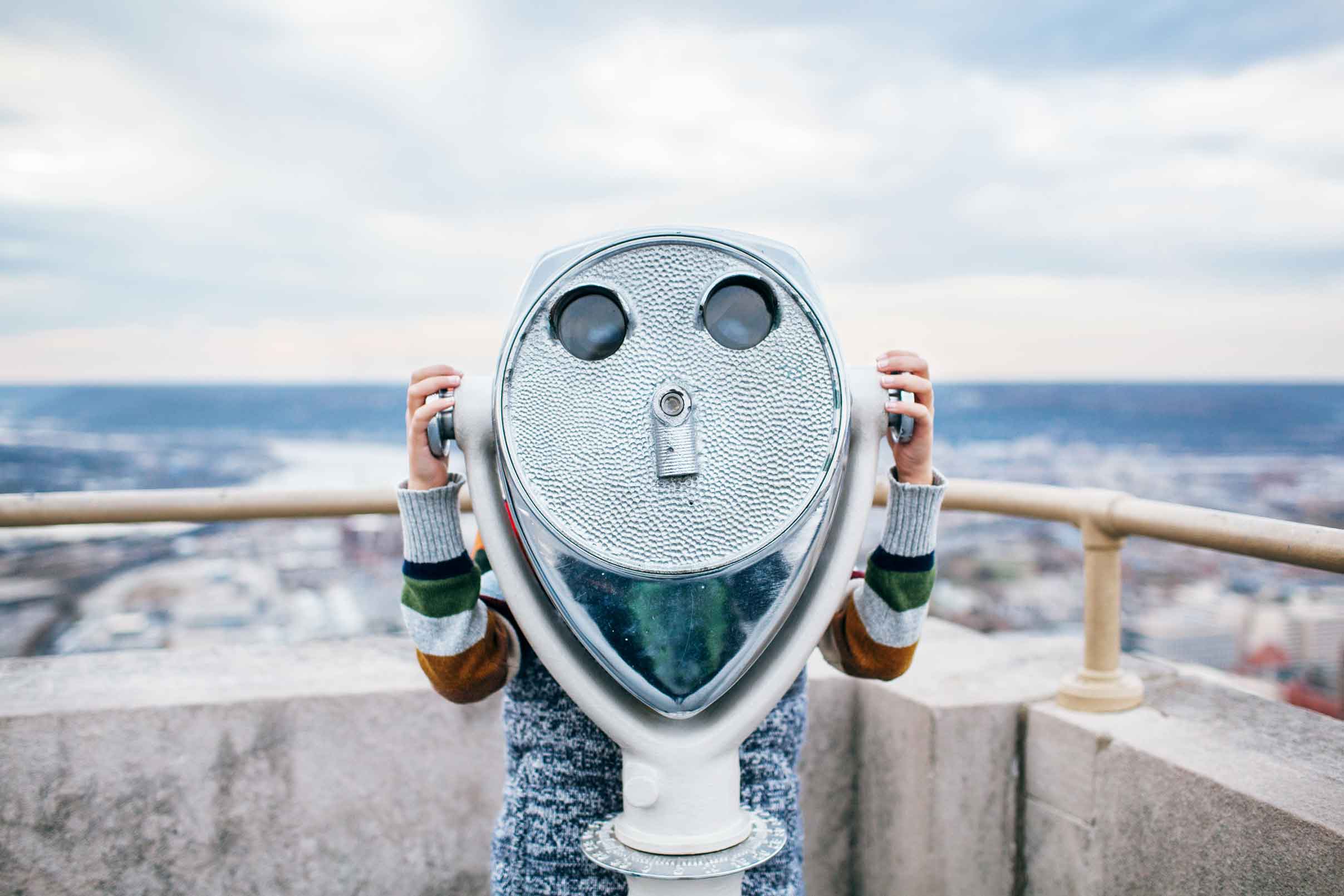 Binoculars Person on a rooftop looking at the landscape through a viewer